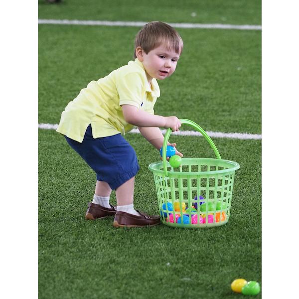 一个男孩放下篮子去捡几个复活节彩蛋
